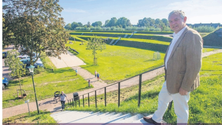 Trap Oostelijke Vestingwallen Muiden. Richard Soeter gebruikt de nieuwe trapleuning. Wethouder Hugo Bellaart wacht hem boven op. 
