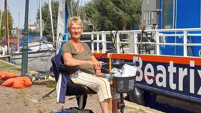 Josee in haar scootmobiel voor de boot Beatrix